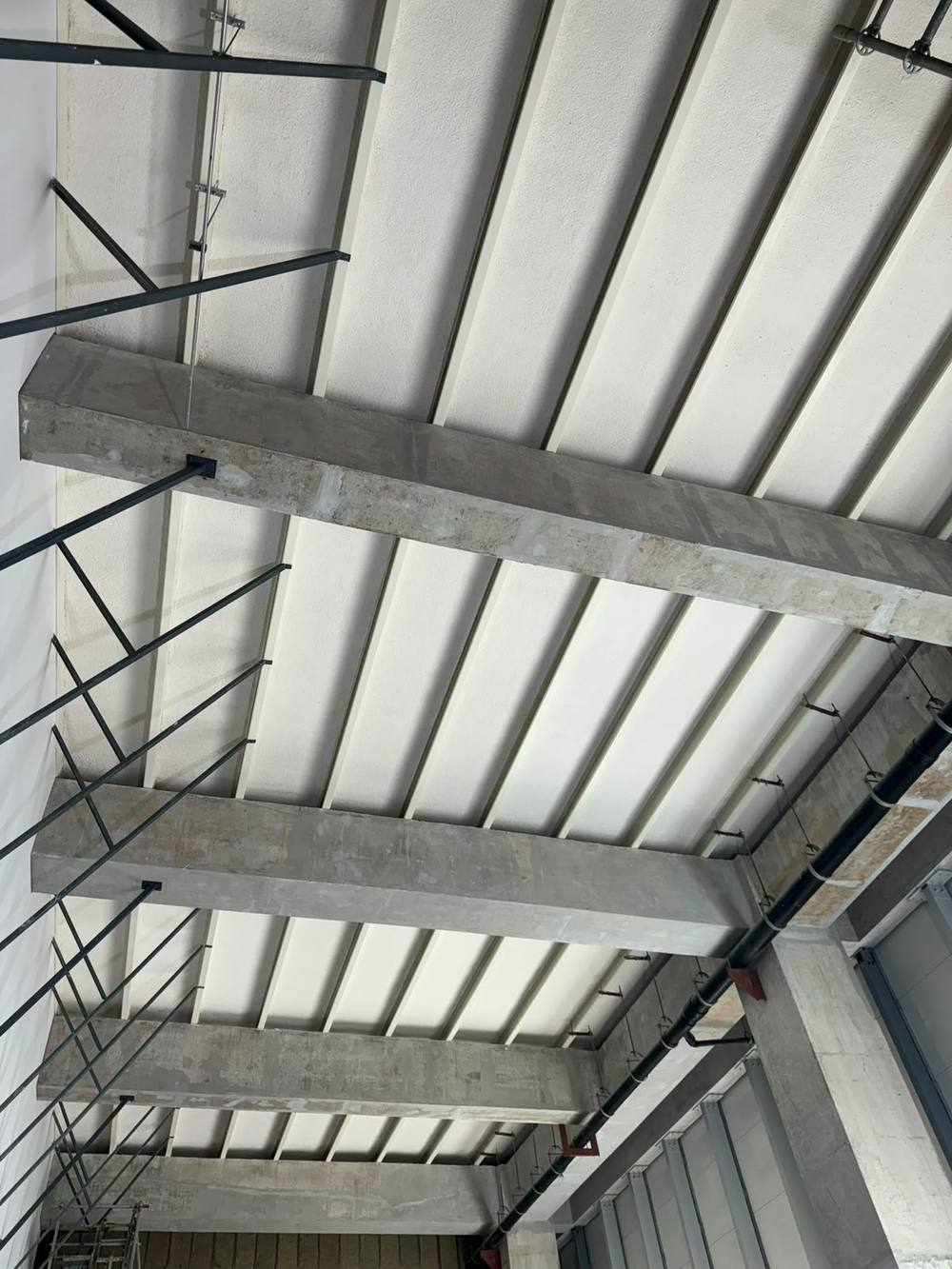 Sprayed to the underside of a metal roof deck